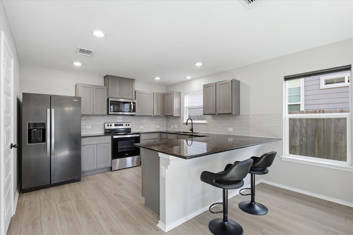 104 Rooster Way Jarrell, TX 76537 - Photo 10 of 33 Polished stone counters and contemporary cabinetry elevate this modern kitchen layout.