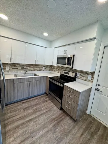 a kitchen with stainless steel appliances granite countertop a stove a sink dishwasher and a refrigerator