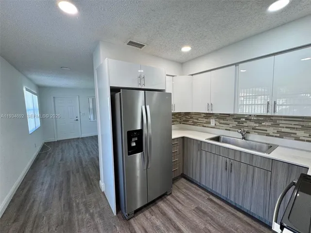 a kitchen with stainless steel appliances granite countertop a refrigerator and a stove top oven