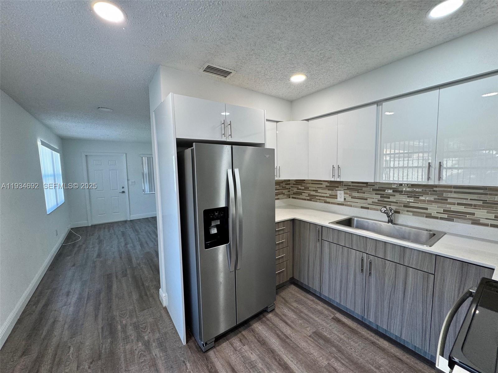 100 Southwest 9th Street, Unit B Hallandale Beach, FL 33009 - Photo 2 of 17 a kitchen with stainless steel appliances granite countertop a refrigerator and a stove top oven