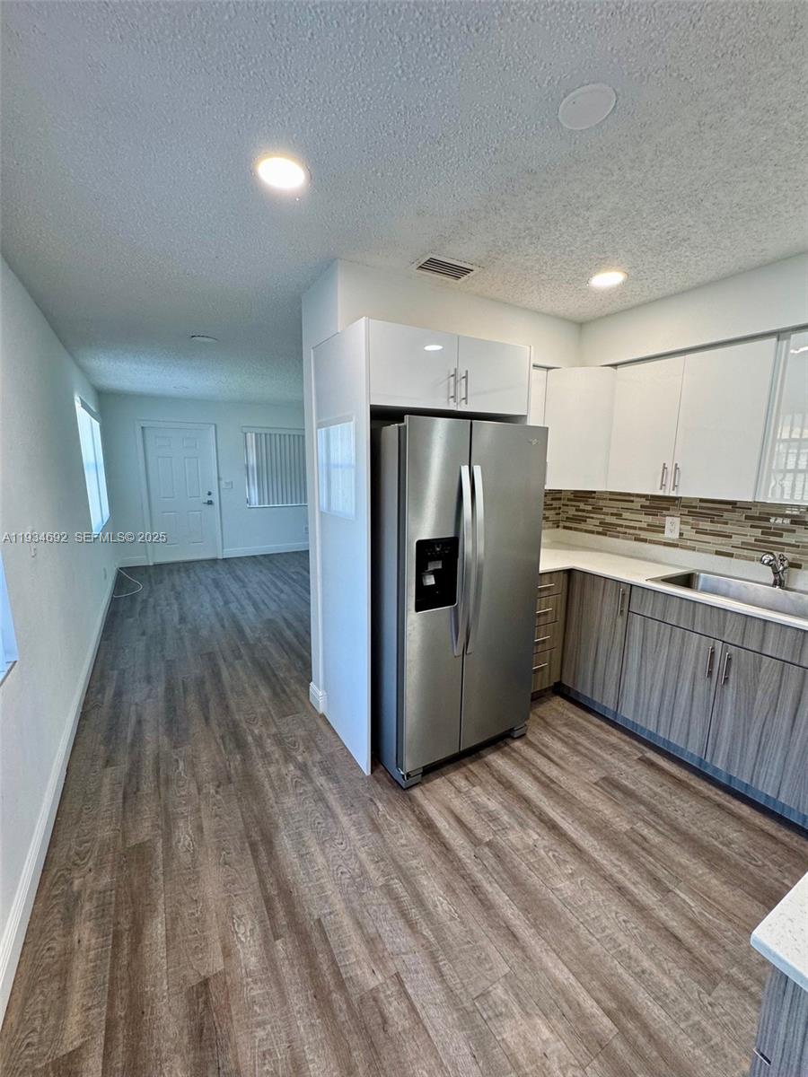 100 Southwest 9th Street, Unit B Hallandale Beach, FL 33009 - Photo 5 of 17 a kitchen with stainless steel appliances a refrigerator and a stove top oven