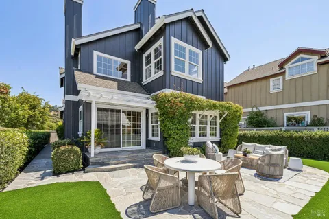 a view of a house with backyard and sitting area