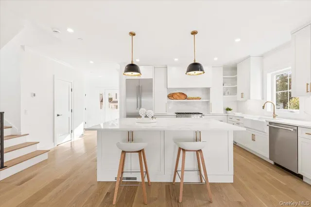 a kitchen with stainless steel appliances granite countertop a sink a stove and a wooden floors