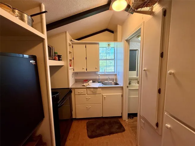 a kitchen with a refrigerator and a stove top oven