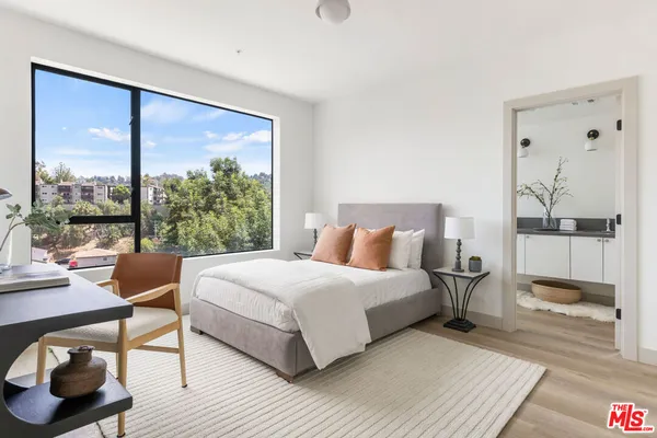 a bedroom with a bed and a large window
