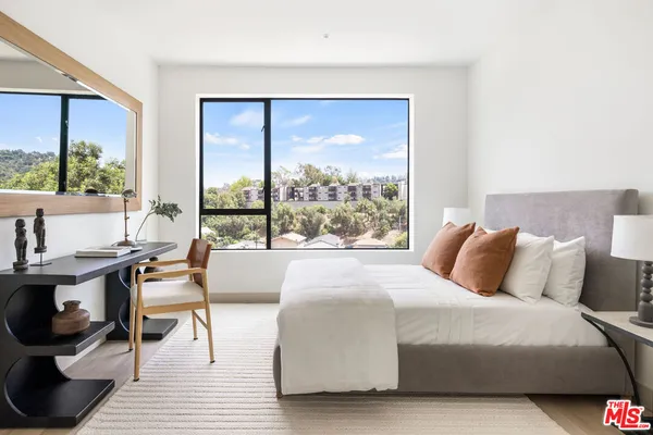 a bedroom with a large window and a bed