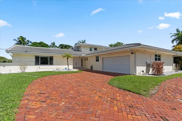 a front view of a house with a garden and yard