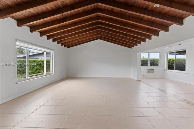 a view of an empty room with wooden floor and windows