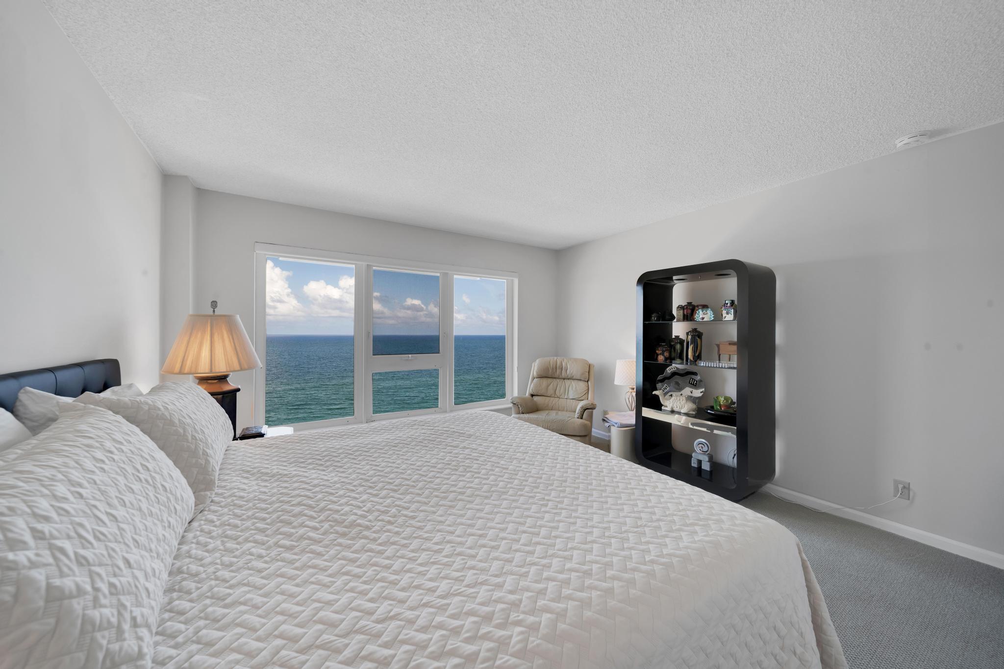 2066 North Ocean Boulevard, Unit 12NE Boca Raton, FL 33431 - Photo 31 of 53 a large bed sitting in a bedroom next to a window