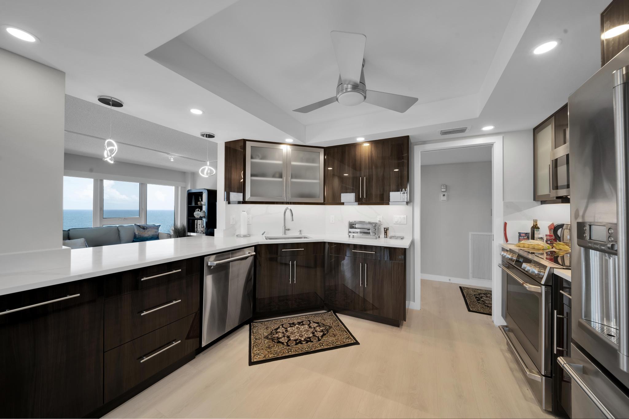 2066 North Ocean Boulevard, Unit 12NE Boca Raton, FL 33431 - Photo 6 of 53 a kitchen with stainless steel appliances kitchen island granite countertop a stove and cabinets