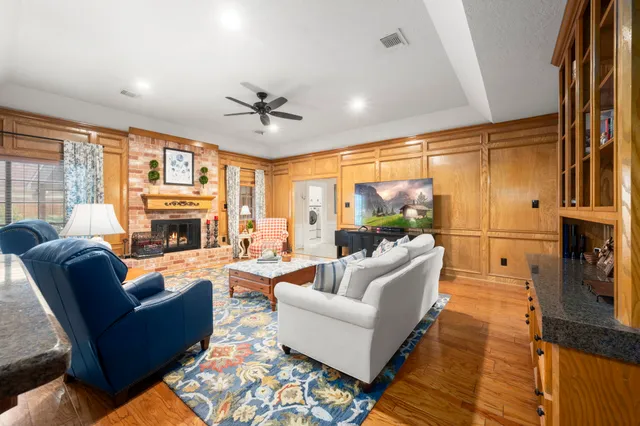 a living room with furniture a fireplace and a flat screen tv