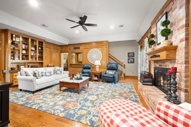 a living room with fireplace furniture and a rug