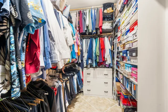 a view of walk in closet with clothes and shoes
