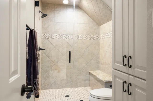 a bedroom with a large bed and a chandelier