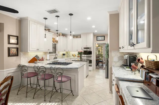 a kitchen with stainless steel appliances kitchen island granite countertop a sink and cabinets