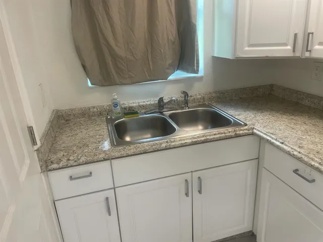 a kitchen with stainless steel appliances white cabinets and a sink