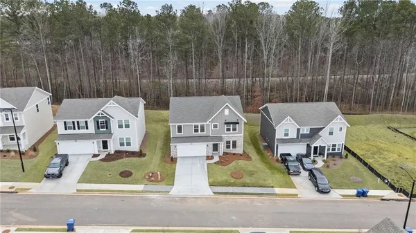 an aerial view of residential houses with outdoor space and parking