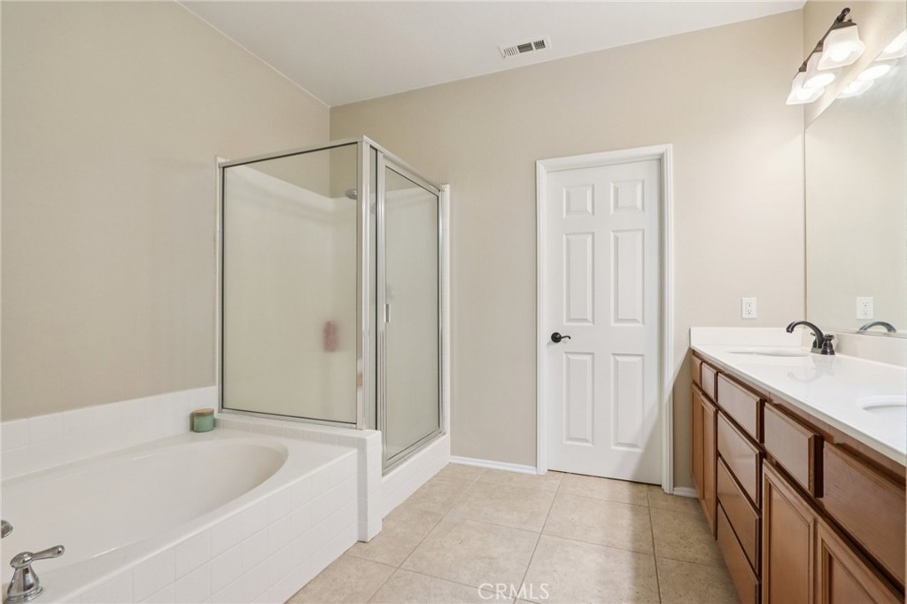 3374 Wind Chime Lane Perris, CA 92571 - Photo 15 of 30 a bathroom with a tub sink and mirror