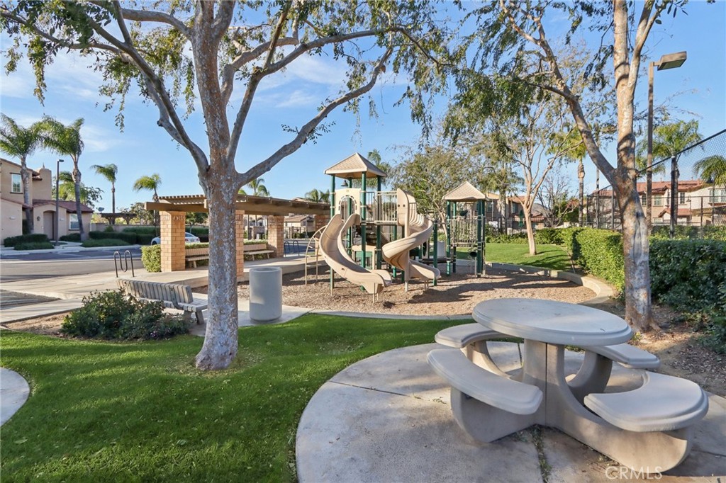 3374 Wind Chime Lane Perris, CA 92571 - Photo 28 of 30 a view of a backyard with table and chairs couches and a fire pit and a large tree