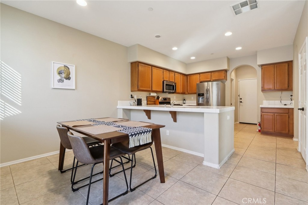 3374 Wind Chime Lane Perris, CA 92571 - Photo 6 of 30 a kitchen with stainless steel appliances a sink a stove a refrigerator cabinets and a dining table