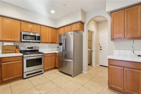 a kitchen with stainless steel appliances granite countertop a refrigerator a stove a sink and a microwave