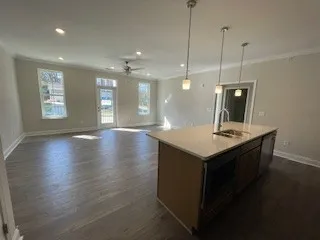 a kitchen with a sink a refrigerator a window and wooden floor