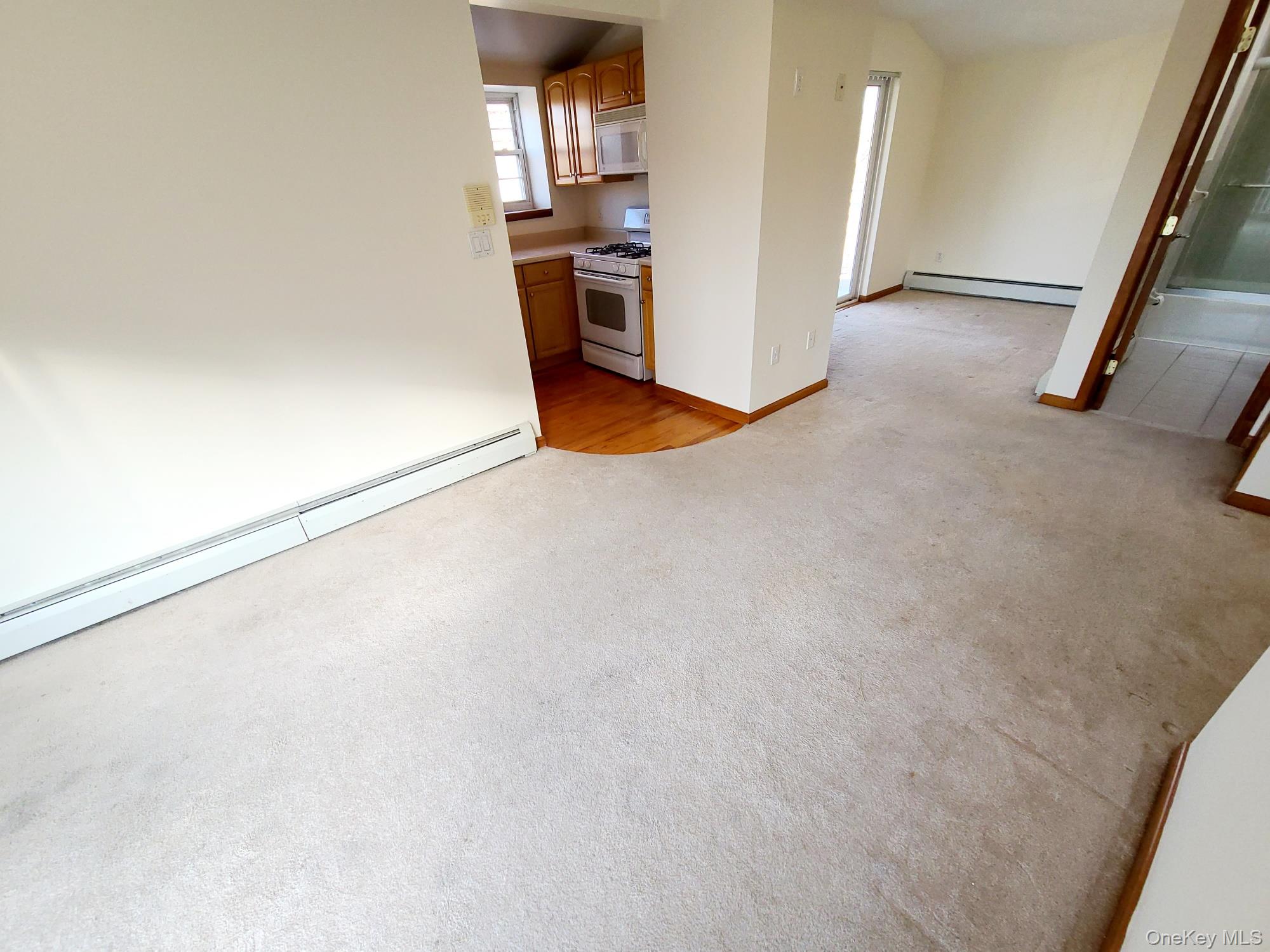67-08 Exeter Street, Unit 3 Queens, NY 11375 - Photo 3 of 18 a view of kitchen and empty room with wooden floor