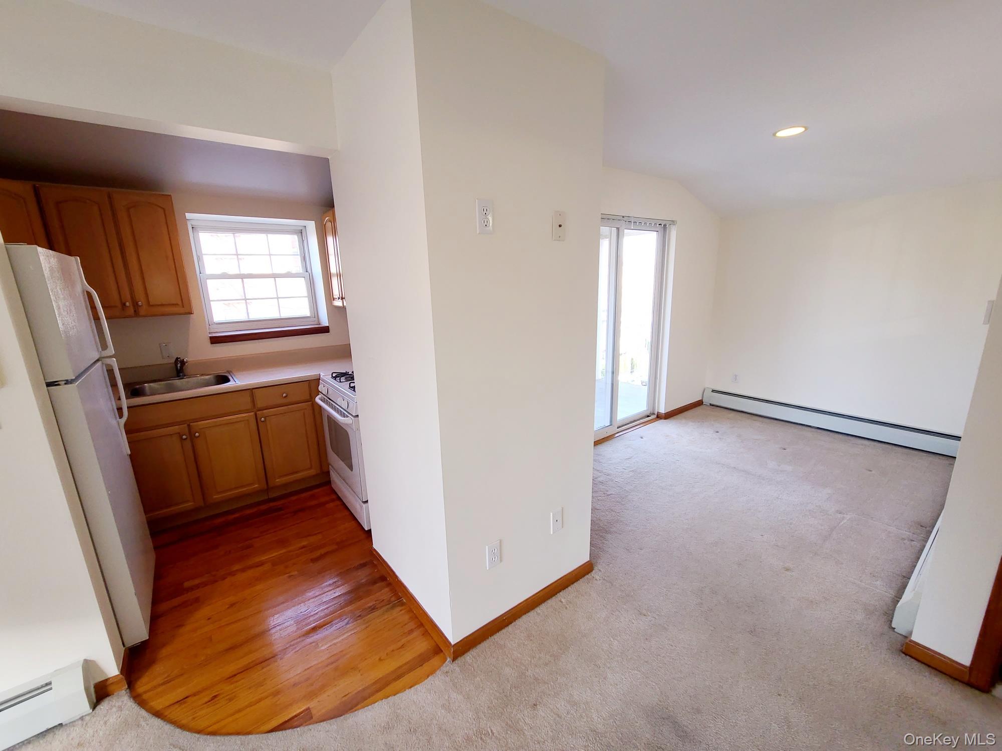 67-08 Exeter Street, Unit 3 Queens, NY 11375 - Photo 4 of 18 a view of an empty room with wooden floor and a window