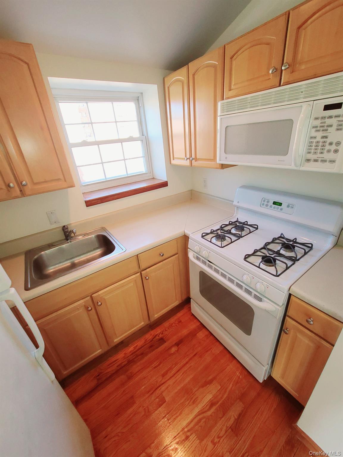 67-08 Exeter Street, Unit 3 Queens, NY 11375 - Photo 8 of 18 a kitchen with granite countertop a stove a sink and a microwave