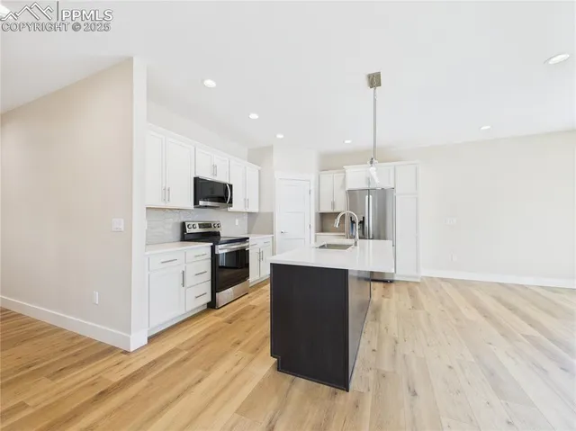 a kitchen with stainless steel appliances kitchen island granite countertop a stove top oven a sink and a microwave