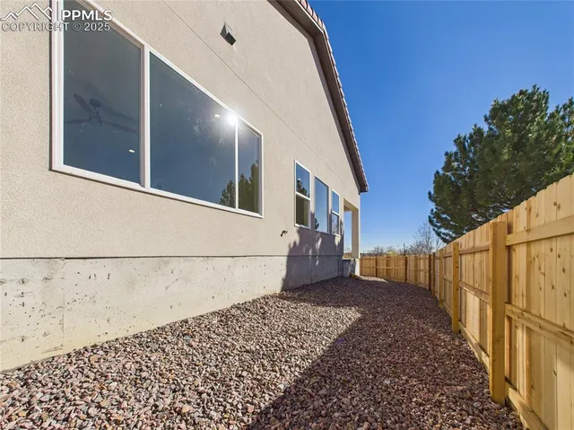 a view of a backyard with wooden fence