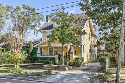 a front view of a house with a tree