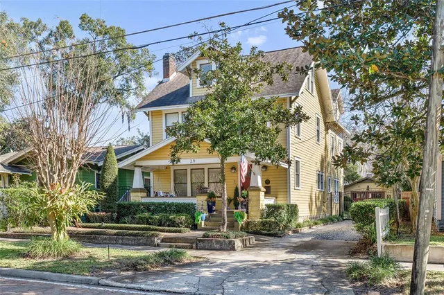 a front view of a house with a tree