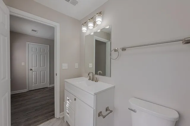 a view of a hallway with wooden floor and a ceiling fan