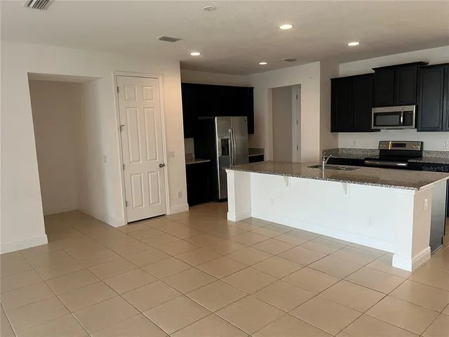 a kitchen with stainless steel appliances a refrigerator sink and microwave