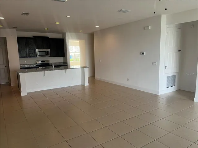 a view of kitchen with stainless steel appliances a refrigerator and a stove top oven