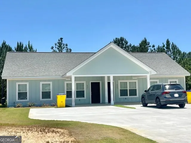 a front view of a house with cars parked