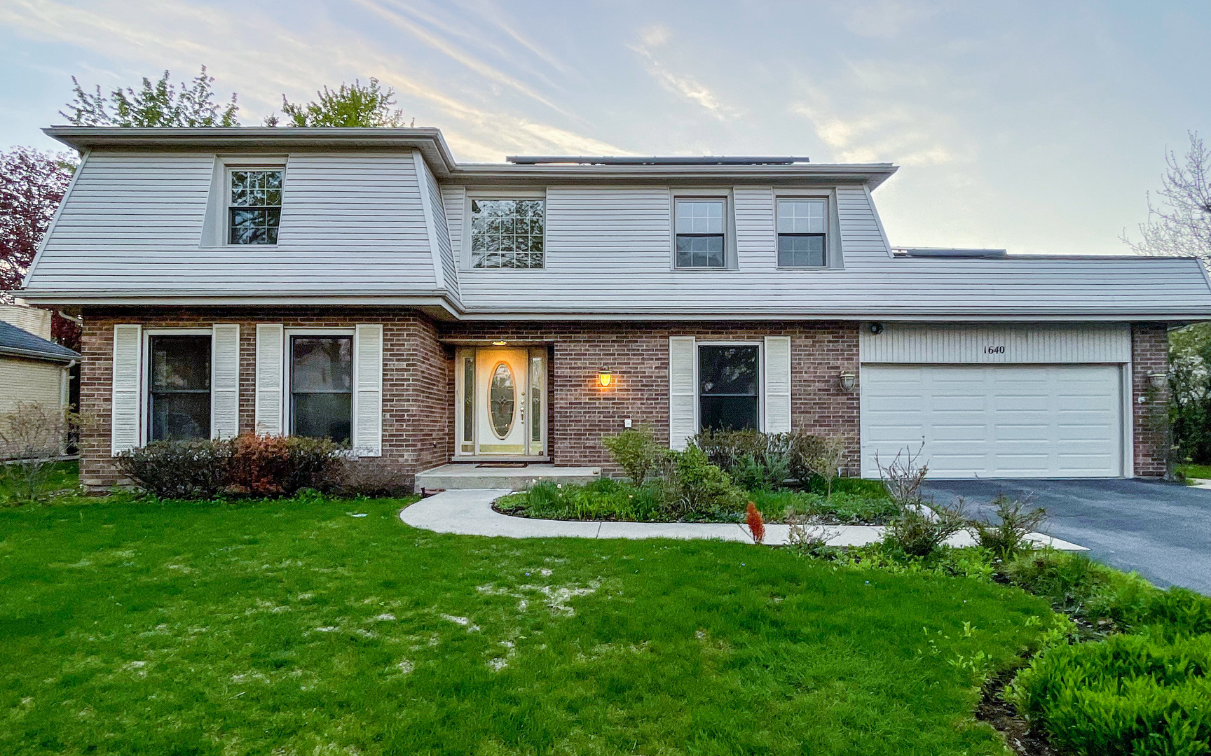 1640 Barry Lane Glenview, IL 60025 - Photo 2 of 42 a front view of a house with a yard and garage