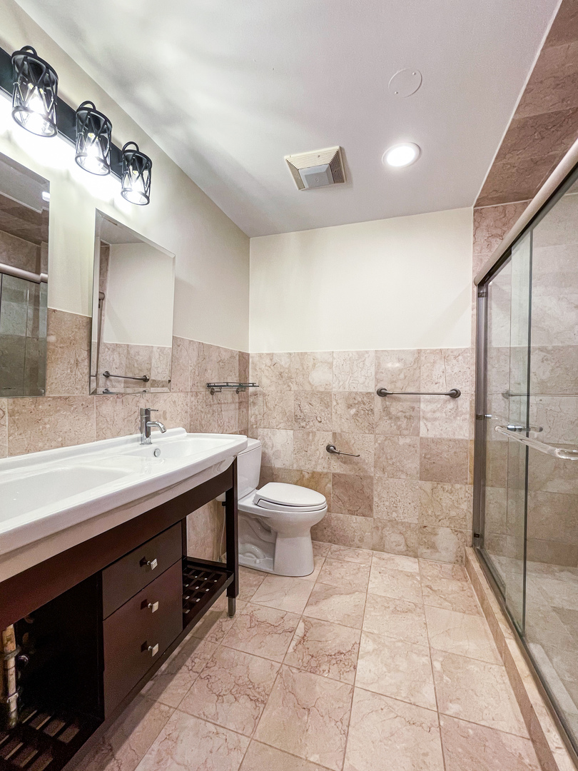 1640 Barry Lane Glenview, IL 60025 - Photo 24 of 42 a bathroom with a double vanity sink a toilet and a mirror