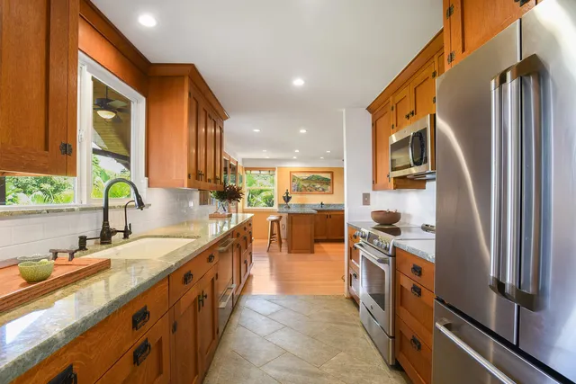 a bathroom with a granite countertop sink and a large mirror