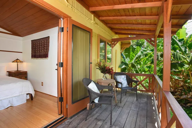 a view of a hallway with wooden floor and a bathroom