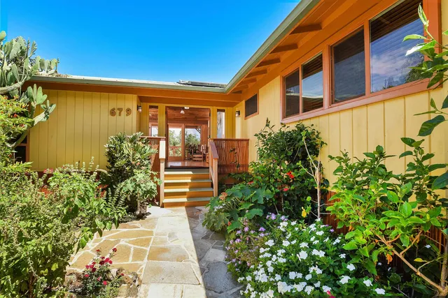 a view of a pathway with a flower garden