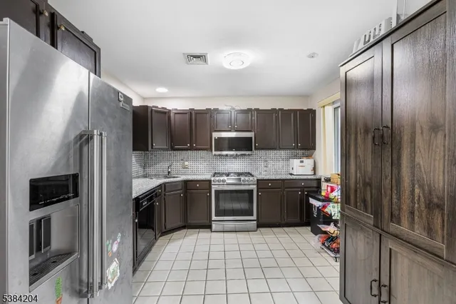 a kitchen with a sink stainless steel appliances and cabinets