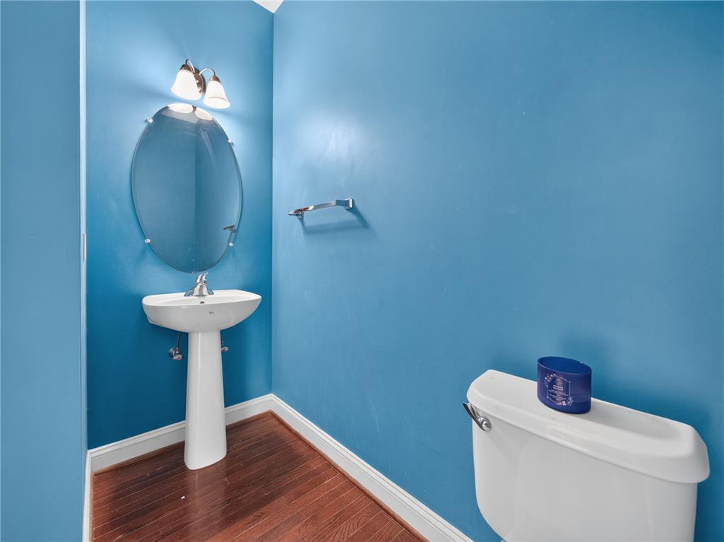 3821 Rittenhouse Road Lower Macungie Township, PA 18062 - Photo 56 of 62 A compact and functional powder room with rich hardwood flooring and a classic pedestal sink.