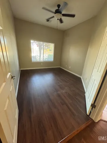 a view of a livingroom with wooden floor and a ceiling fan
