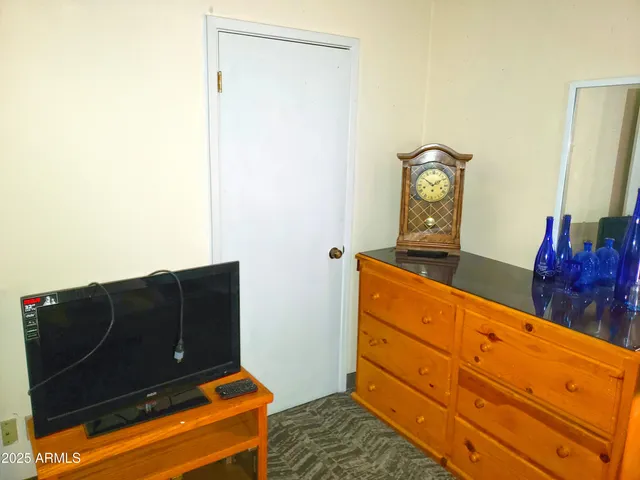 a view of a hallway to an empty room with a window