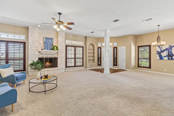 a living room with furniture a fireplace and a chandelier