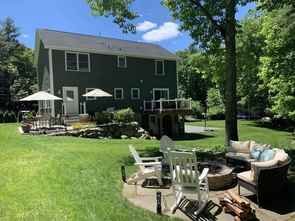 a front view of a house with garden and sitting area