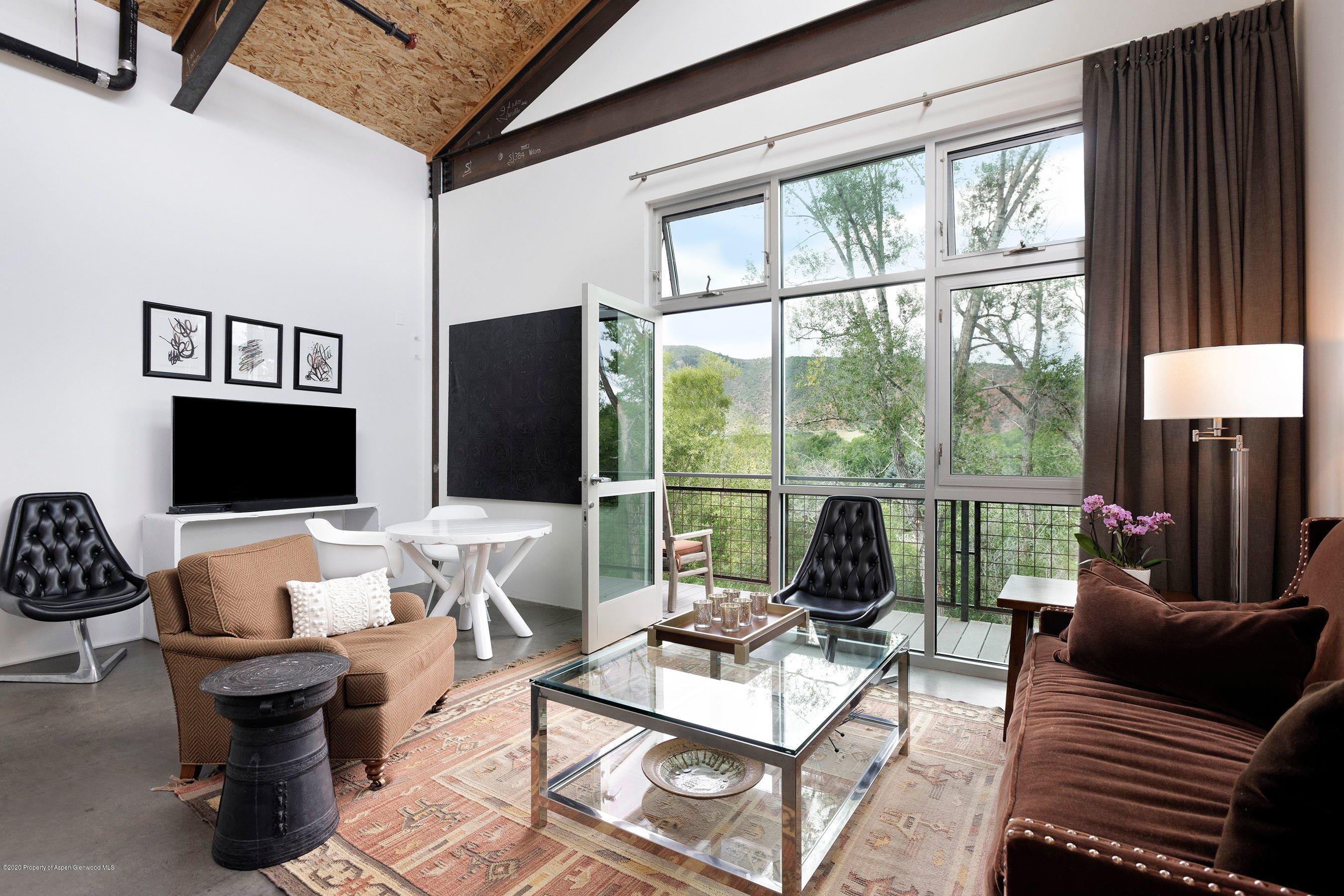 35 Widget Street, Unit 516 Basalt, CO 81621 - Photo 4 of 14 a living room with furniture floor to ceiling window and a flat screen tv