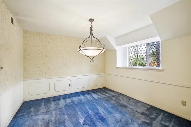 a view of an empty room with wooden floor and window